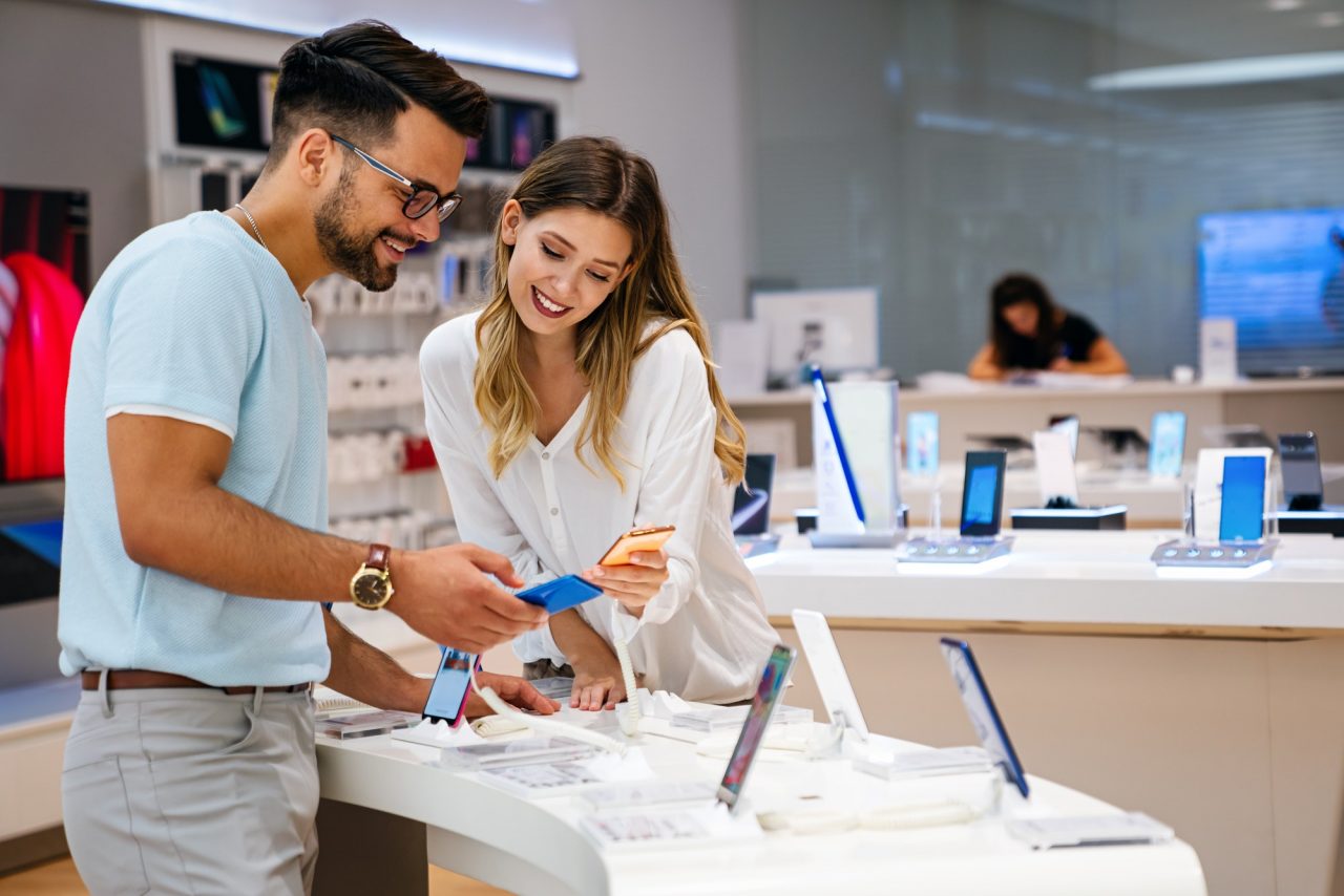 shopping a new digital device happy couple buying a smartphone in store 1.jpg